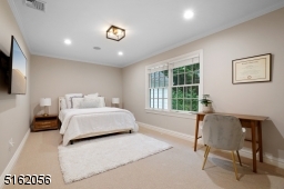 Bedroom 5 with wall-to-wall carpeting, recessed lights, modern barrel light fixture, paneled walls, wallpaper and two double French door closets with built-ins