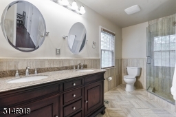 decorated in a neutral decor with two sinks, stall shower