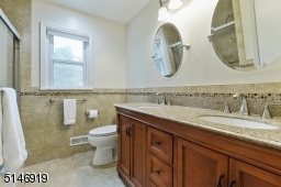 new main bathroom with two sinks, shower over tub