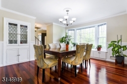 spacious Formal Dining Room with a new bay window, built-ins, china cabinet, crown molding / wainscoting + wood floors