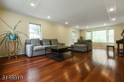 large sun-lit  Formal Living Room with new windows, wood floors, recessed lights, crown molding