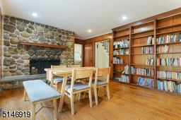view of the family room, warm and inviting stone wood-burning fireplace, built-ins