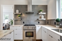 Industrial-effect Italian backsplash tile and a marble waterfall island (Montclair Danby marble) with extra storage - stone procured and crafted locally. The rest of the kitchen is fitted with a white Caesar Quartz stone counter. High-end SS appliances.