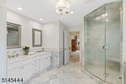 Primary bathroom features a glass-enclosed walk-in shower with a built-in bench, soaking tub with a wall-of-windows, floor-to-ceiling linen closet and a separate commode room with an architectural window