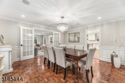 Dining Room features crown molding, paneled walls, modern crystal chandelier, recessed lights, built-in speakers and double glass French privacy doors which lead to the Family Room as well as separate direct access to the Kitchen