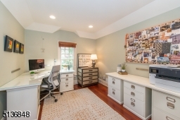 Another bright built-in workspace features French doors and a Juliet balcony overlooking the family room below.