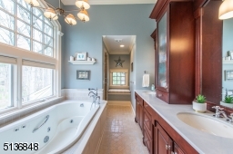 The en suite owner's bath soothes with heated floors, a jetted soaking tub, a steam shower with a handheld sprayer, a wide double vanity with abundant storage and a private water closet.
