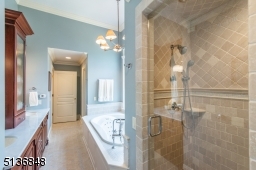The en suite owner's bath soothes with heated floors, a jetted soaking tub, a steam shower with a handheld sprayer, a wide double vanity with abundant storage and a private water closet.