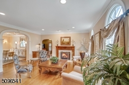 Living room with hardwood flooring and double sided fireplace. Li