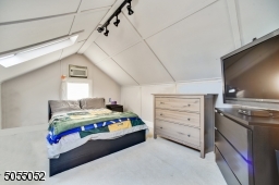 Bedroom 4 featuring a vaulted ceiling, skylight, track lighting and walk-in closet