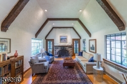 Overflowing with space, comfort and charm, this sundrenched living room with hand-hewn beamed cathedral ceiling, a stunning stone fireplace and large windows flows seamlessly to the kitchen, dining room and wraparound screened-in porch.