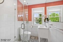 Featuring new sink, toilet, tile floor, glass doors around stall shower