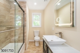 2nd full bathroom with custom shower doors, touch screen mirrors recessed lighting.