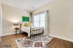 Bedroom 3 with hardwood floors, a walk-in closet and double windows