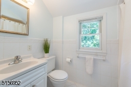 Updated bathroom in white neutrals with shower over bathtub