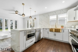 Beautiful gourmet kitchen overlooks breakfast bar into cozy den that is perfect for a home office, a homework space, or a place to snuggle up and watch TV.