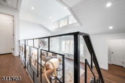 Black iron railing with gold accents showcases the breathtaking navy wall upstairs and overlooks the stunning living area below.