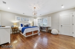 Bedroom 3 featuring hardwood floors, baseboard molding, crown molding, two exposures of windows, ceiling fan, recessed lights, oversized large walk-in fitted closet, shared Full Bathroom