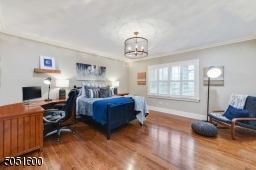 Bedroom 4 featuring hardwood floors, baseboard molding, crown molding, fitted closet, recessed lights