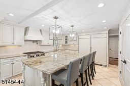 Two dishwashers, wine fridge, built-in work area with glass display cabinets, crisp white custom wood cabinetry, new thassos brick subway tile backsplashes, granite counters, double fitted pantry, & pasta pot water filler.