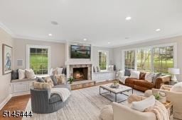 Family Room is an open concept to the Kitchen, overlooks Canoe Brook Country Club golf course and features three exposures of windows, hardwood floors, a stone wood burning fireplace flanked by two windows / window seats with storage and recessed lights