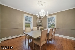 Dining Room featuring hardwood floors, deep base moldings, built-in original corner china cabinet and chair rail