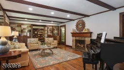 Stone woodburning fireplace with hand-carved oak mantle, beamed ceiling, ten-panel chestnut doors, French door to rear yard, custom built-ins, double French doors to library/office