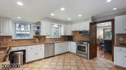 Updated eat-in kitchen with stainless steel appliances, custom tile backsplash, breakfast counter & pantry