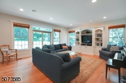 Welcome to your sun-drenched family room that is surrounded by windows and a beautiful built-in entertaining system.