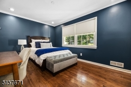 Bedroom 3 with hardwood floors, base and crown moldings, recessed lights, a double window and double fitted closet