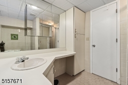 Full Bathroom with tile floors, a vanity and a glass enclosed shower