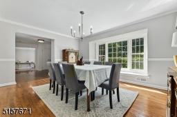 Dining Room with hardwood floors, chair rail, deep base and crown moldings, Bay window with window seat and a modern light fixture