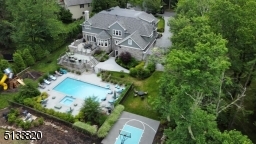 Fabulous yard with terraced patio, in-ground heated pool, spa, professionally surfaced basketball half court, playground