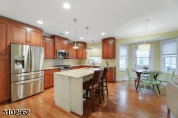 Subway tile backsplashes and a decorative design behind the oven, double door floor to ceiling pantry, stainless steel appliances including a Samsung refrigerator, and KitchenAid stove and dishwasher, window over the sink
