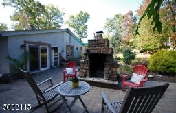 Large Stone Woodburning Fireplace sits on Tiled Patio, perfect for cold nights!