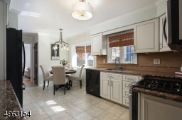 Renovated eat-in kitchen with glazed shaker style cabinets, granite counters, stone subway tile back splash, bamboo shades
