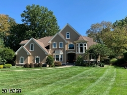 The home sits commandingly back from the curb set behind a fabulous stretch of lush lawn nestled within a cul-de-sac of designer residences.