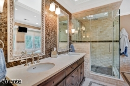 This completely redone master bath offers an oversized stall shower, twin vanities, intricate tile work and a free-standing soaking tub.
