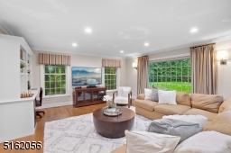 Game Room / Leisure Room with hardwood floors, recessed lights, deep moldings, , built-in workstation with open shelving, three exposures of windows and glass sliders which lead to the rear paver patio