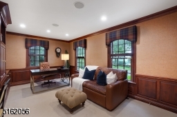 Office features wall-to-wall carpeting, walk-in closet, three exposures of windows, wood paneled walls, deep moldings, wood built-in desk, shelves and storage cabinetry, recessed lights and built-in speakers