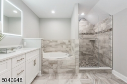A light reflected custom mirrors keeps thing clear and serene.All showerheads overhead and hand held sprays can be turned on at the same time for an amazing spa like experience. Pebbled floor shower.