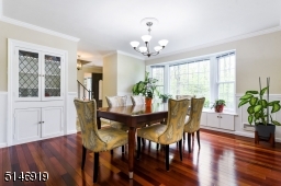 spacious Formal Dining Room with a new bay window, built-ins, china cabinet, crown molding / wainscoting + wood floors