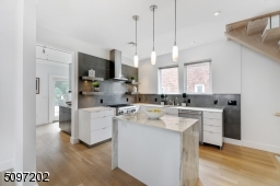Industrial-effect Italian backsplash tile and a marble waterfall island (Montclair Danby marble) with extra storage - stone procured and crafted locally. The rest of the kitchen is fitted with a white Caesar Quartz stone counter. High-end SS appliances.