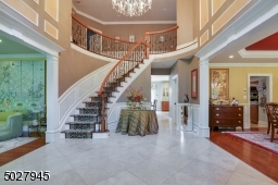 16 x 14 Two story Foyer featuring custom solid wood Double door entry, Schonbek Crystal Chandelier, Sentry Closets, Curved Stair case and custom Handrail & Iron Balusters, wool carpert runner, 24" Travertine Tile flooring
