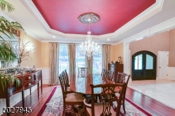 16' x 15' featuring Tray Ceiling, Schonbek crystal chandelier and ceiling medallion, Schonbeck crystal sconces, recessed lighting, white oak flooring with inlay