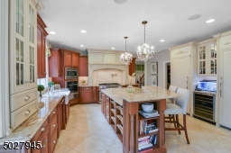 15' 4" X 15' 2 Two-tier center island wit corbels and breakfast seating/additional drawer and cabinet storage/electrical outlet. Imported brazillian Nacarado quartzite Countertops, Schonbek Crystal Chandeliers