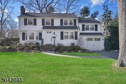 Beautifully landscaped front yard! White wood-shingled siding complimented by classic black shutters.