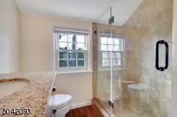 Tiled walk-in shower with floor to ceiling glass door entry and separate Linen Closet.