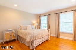 Large bedroom with recessed lighting located near double sink vanity hall bathroom with additional closet space