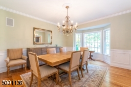 Formal Dining Room with wainscoting picture frame molding, built in speakers and a bay window make dinner parties great fun!